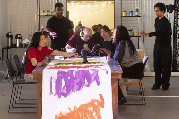 Michael Beard working on an artwork with a group of people during his residency at MIF23