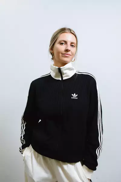 Rosie Callaghan wearing a black Adidas jacket and white trousers