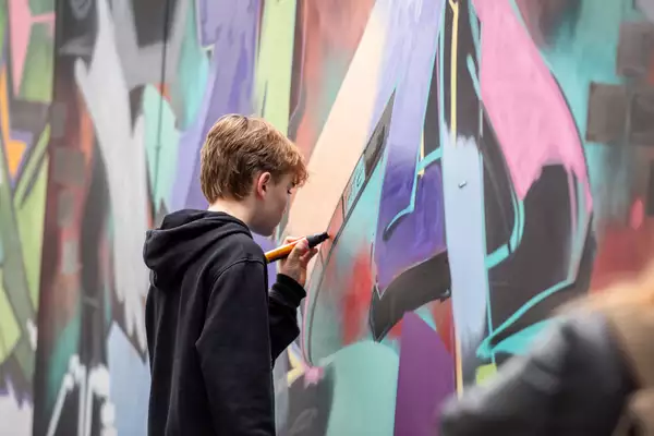 A person looks at a graffiti wall at the Street Culture Takeover event at the Welcome at Aviva Studios