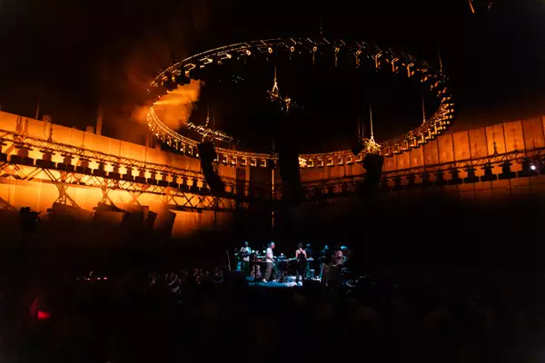 A group shot of the performers during Everything is Recorded. The stage is in the round.