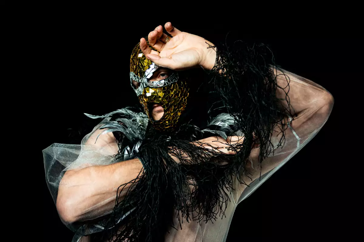 Keiran Jones wearing a glittered mask and feathers