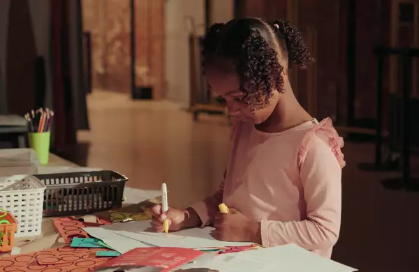 A child colouring in at a table in the Social