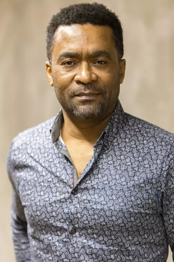 Portrait photograph of Georges Moyat wearing a blue patterned shirt