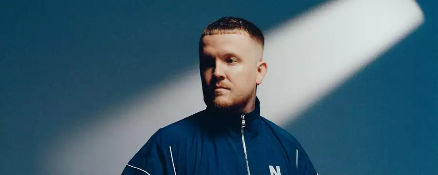 Chris Stussy on a blue background with a shadow across his face