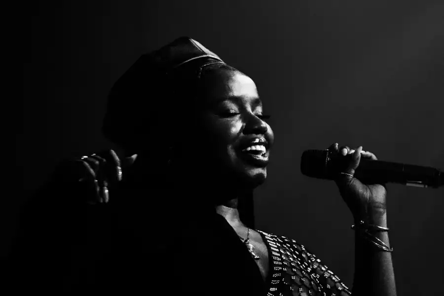 Black and white photo of Misha B singing into a microphone