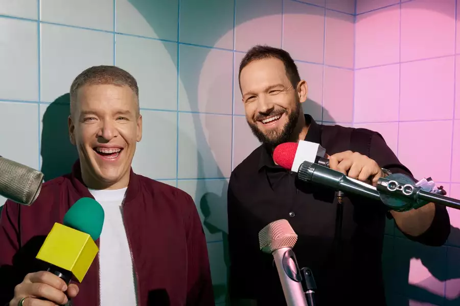 Paczes & Lotek smiling and holding microphones