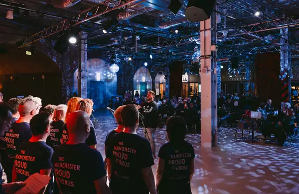 Manchester Proud Chorus performing in the Social with dim lighting and disco balls