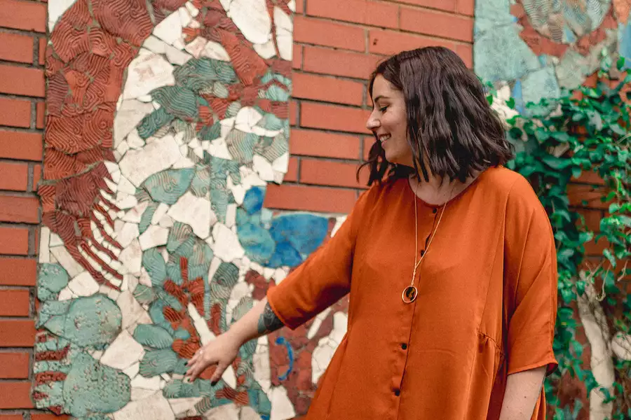 Photograph of a person pointing at street art on a wall