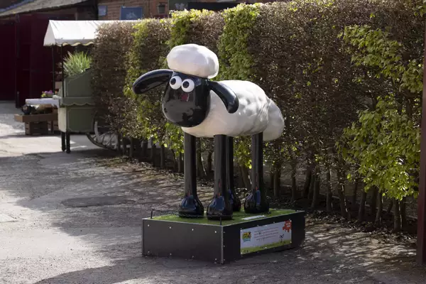 A Shaun the Sheep sculpture outside in a garden