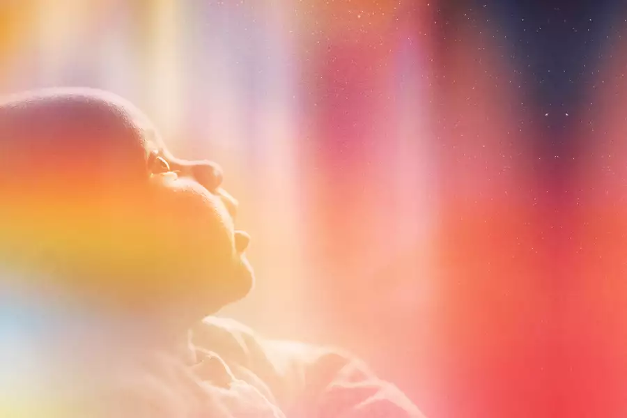 A photograph of a baby staring up in wonder at the night sky