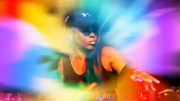 DJ Sequinella with a rainbow background