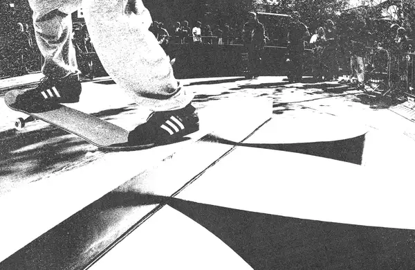 Black and white image of someone skateboarding on an Adidas skate ramp wearing Adidas trainers