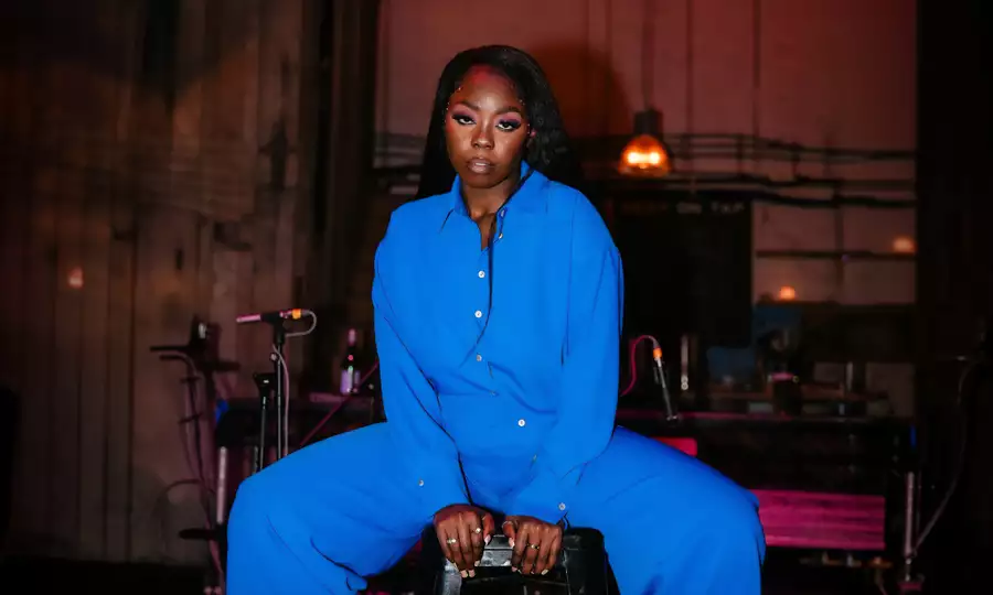 Joy Ogboko wearing a bright blue jumpsuit