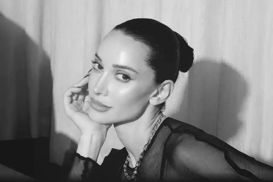 Black and white headshot of Roxie Nafousi sat with her hand resting on her face.