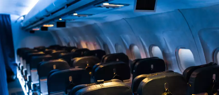The inside of an aeroplane cabin as part of the FLIGHT experience. The lighting is blue.