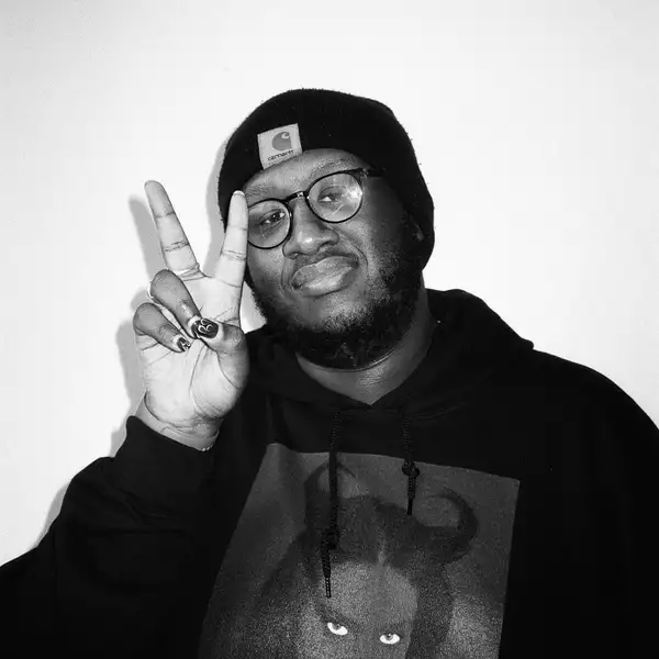 Black and white photograph of Joshua Drakes doing a peace sign