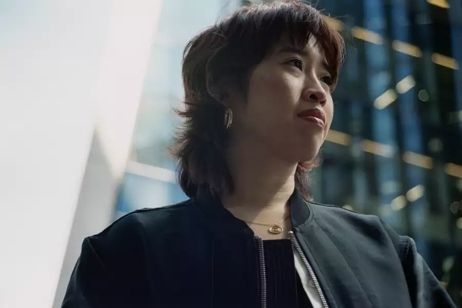 Headshot of Zing Tsjeng with a blurred glass building in the background